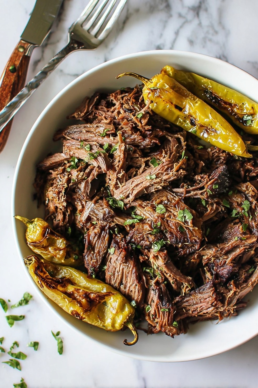 Mississippi Pot Roast - A white bowl filled with many pieces of shredded brown meat with some black edges, sprinkled with small bits of chopped green herbs. On one side, there are three roasted light greenish-yellow peppers with brown char marks. The bowl sits on a white marbled surface, next to a fork with a wooden handle. photo taken with an iphone --ar 2:3 --v 7