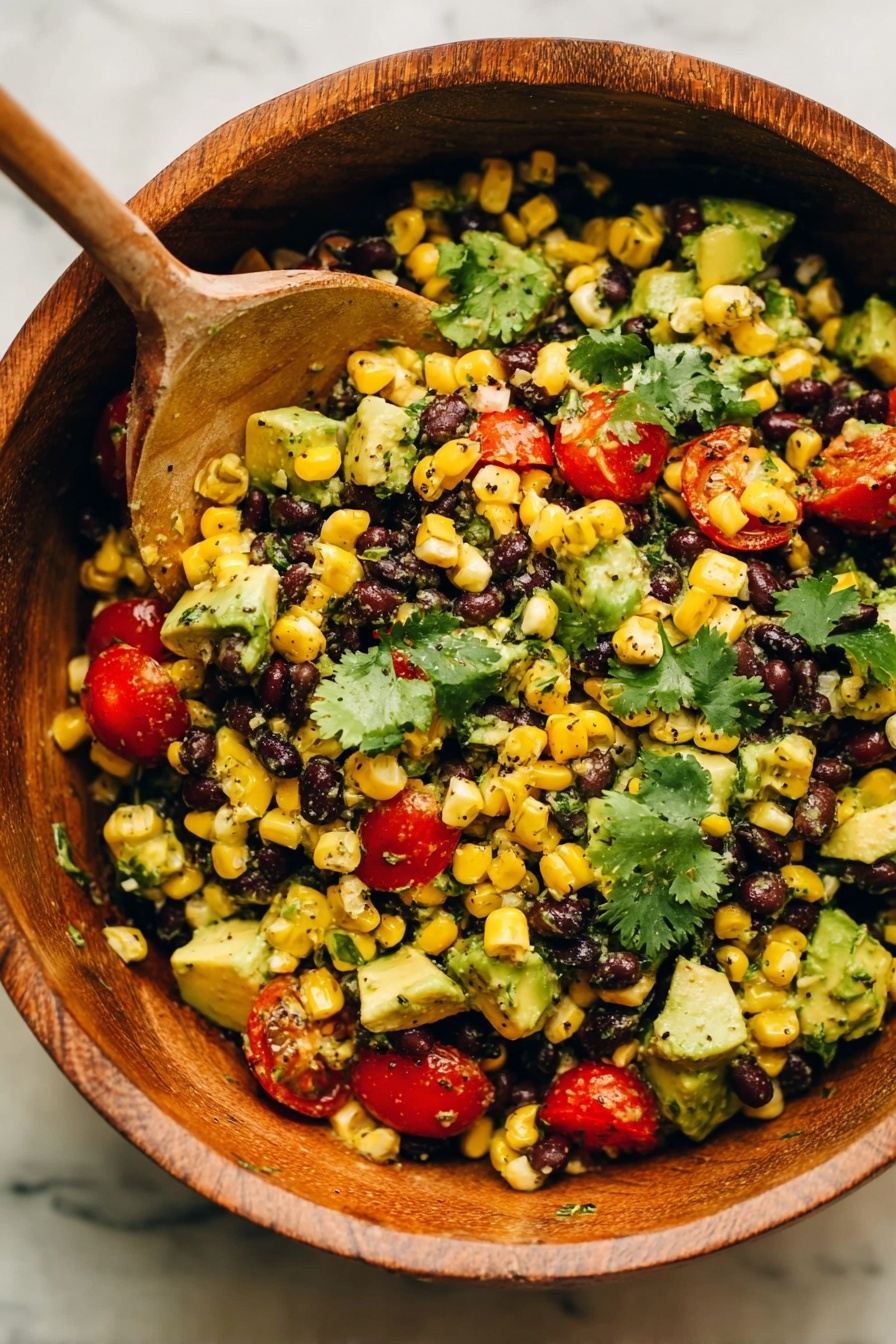 A wooden bowl filled with a colorful salad made of multiple layers including black beans, bright yellow corn kernels, chunks of green avocado, and small red cherry tomatoes, all mixed together and garnished with fresh green cilantro leaves; a wooden spoon rests inside the bowl scooping up some of the salad, and the bowl is placed on a cloth with beige and white stripes over a white marbled surface photo taken with an iphone --ar 2:3 --v 7