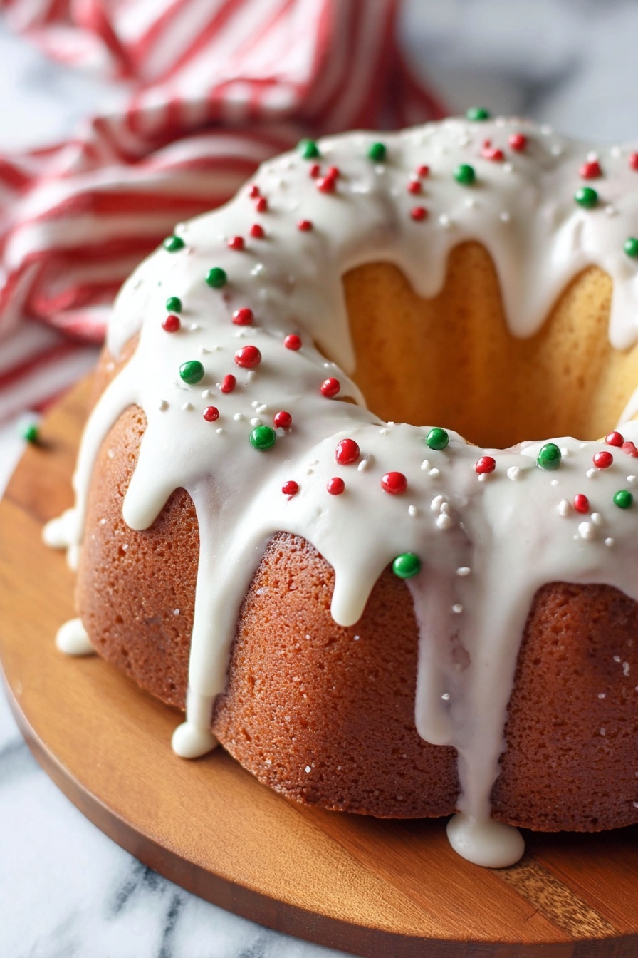 A round bundt cake with a light golden brown color sits on a wooden board, showing its smooth texture and curved ridges. The cake is covered in a thick layer of white icing that drips down the sides in uneven streams. Small red and green round sprinkles are scattered evenly on top of the icing, adding a festive look. In the background, there is a red and white striped cloth partially visible, and the whole scene is set on a white marbled surface. photo taken with an iphone --ar 2:3 --v 7
