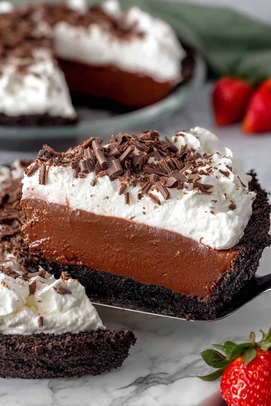 A close-up of a rich dessert pie with four distinct layers, placed on a white marbled surface. The bottom layer is a dark, crumbly chocolate crust forming the base. Above that is a thick, dense band of smooth milk chocolate filling that looks creamy and soft. The third layer is glossy, dark chocolate ganache that is thinner than the filling but shiny and smooth. Topping the pie is a fluffy, white whipped cream layer, thickly spread and topped with scattered dark and milk chocolate shavings, adding texture and color contrast. A slice is being lifted by a spatula, and there are fresh, halved strawberries with green tops on the white marbled surface near the pie. Photo taken with an iphone --ar 2:3 --v 7