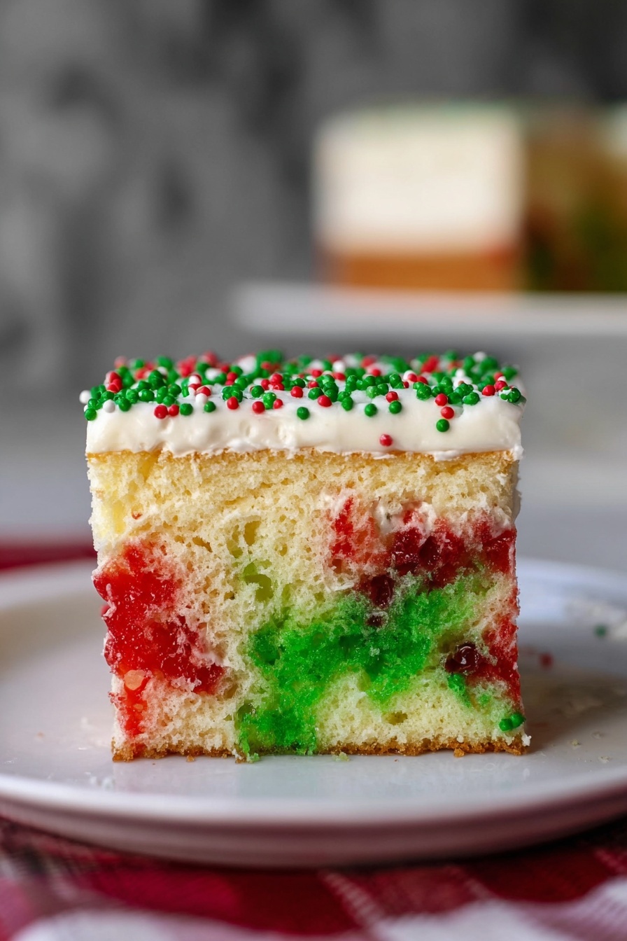 The image shows a slice of festive cake held by a woman's hand, lifted from a white dish on a white marbled surface. The cake has two main layers: the bottom layer contains a soft, sponge-like texture with green and red coloring swirling through a pale yellow base, and the top layer is about half the thickness of the sponge layer, with smooth white frosting. The frosting is decorated with scattered red and green round sprinkles, along with tiny green and red sugar crystals, giving it a holiday look. The larger dish behind holds the rest of the cake cut into square pieces, each topped with the same festive decoration. Photo taken with an iphone --ar 2:3 --v 7