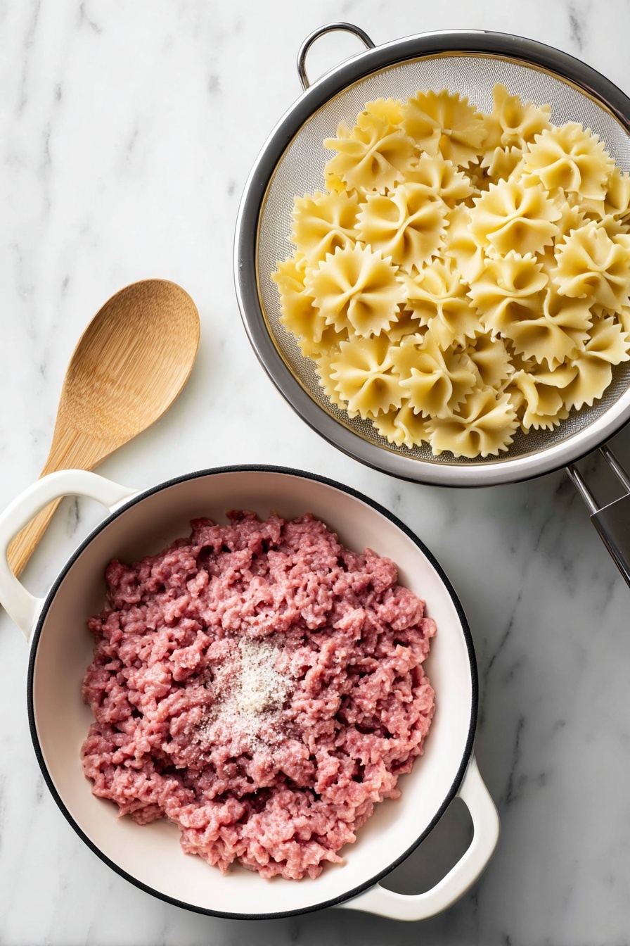 A close-up of a fork holding a bite of farfalle pasta with layers including light yellow pasta shapes at the bottom, topped with browned ground meat, melted shredded yellow cheese, half of a red cherry tomato, small bits of green parsley, and a light drizzle of white sauce. The background shows more pasta mixed with similar ingredients inside a white bowl, all set on a white marbled surface. The overall colors are warm with reds, yellows, browns, and greens. photo taken with an iphone --ar 2:3 --v 7