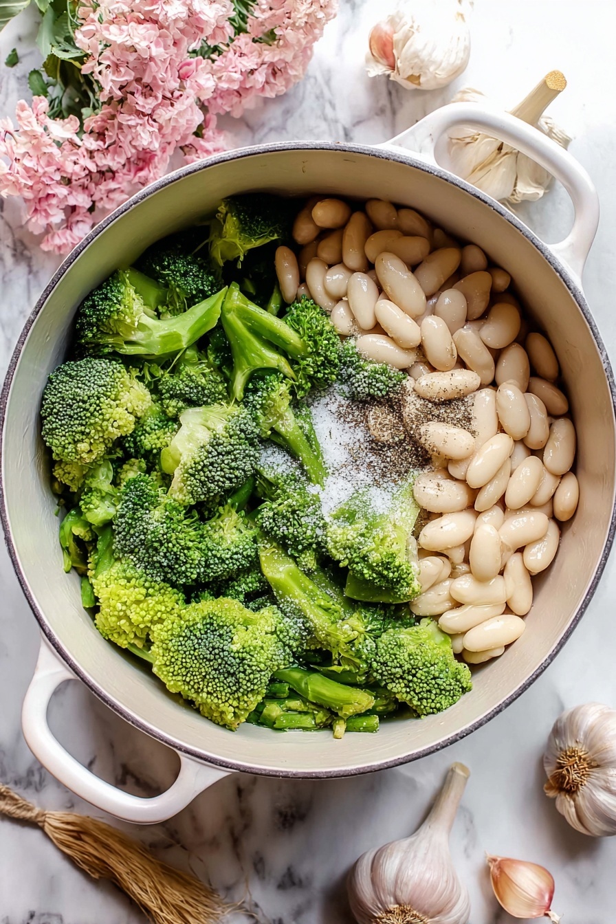 A white bowl filled with a thick green soup forming the first layer, with a creamy white dollop placed in the center as the second layer. Around the dollop, a drizzle of reddish-orange oil is swirled, and thin slices of red chili peppers along with small green leaves are scattered on top. The bowl sits on a white plate with floral designs, all set on a white marbled surface. A knife with a beige handle is placed inside the bowl. Photo taken with an iphone --ar 2:3 --v 7