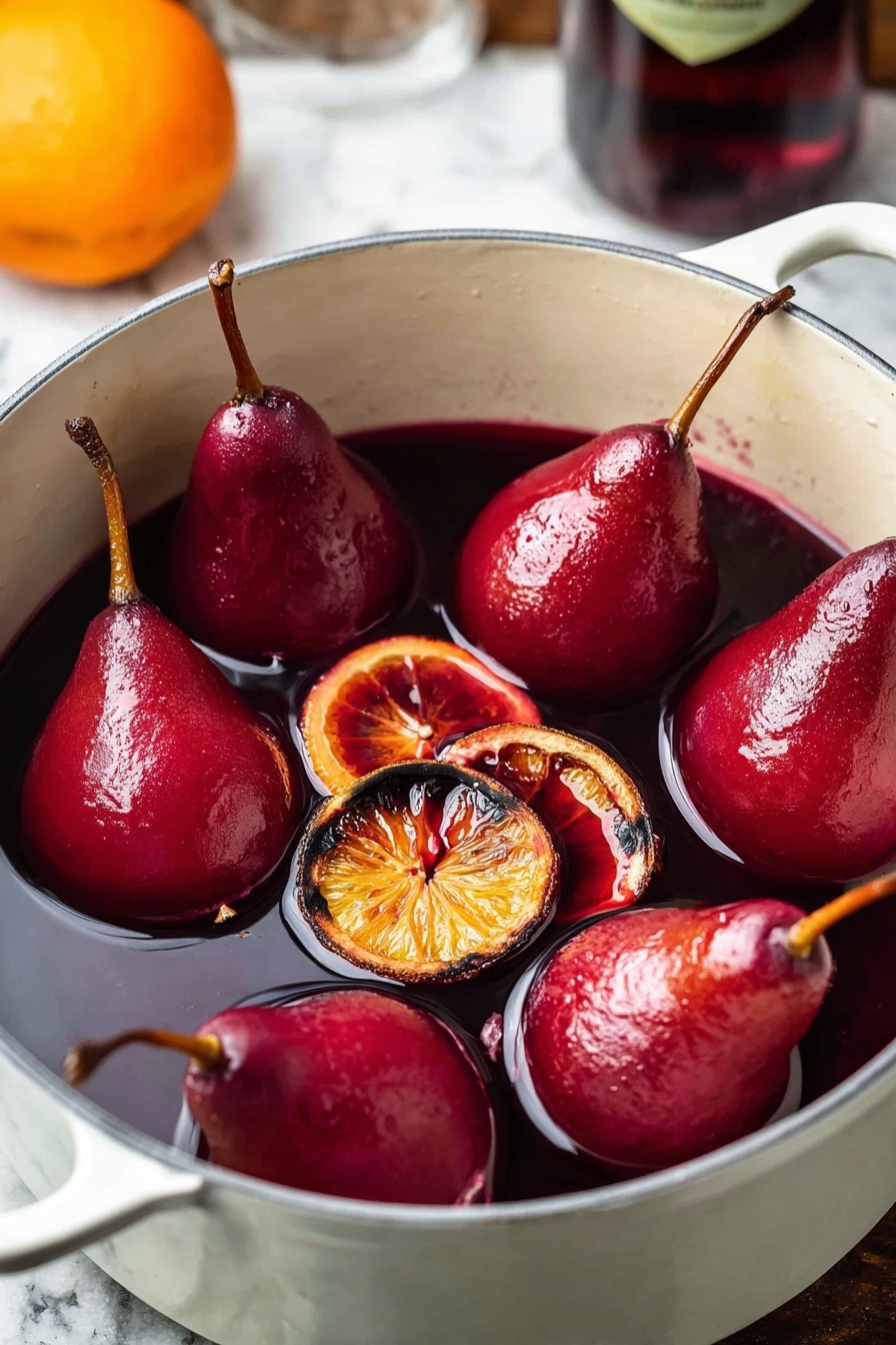 The image shows a white pot filled with six whole red poached pears with their brown stems still attached, floating in deep red liquid, likely wine or syrup. Scattered around the pears are several dark orange slices with a slightly charred look. The pot sits on a surface with white marbled texture, and the background shows a blurred bottle and a hint of an orange in the corner. The pears have a smooth, shiny texture, and the liquid looks thick and rich. Photo taken with an iphone --ar 2:3 --v 7