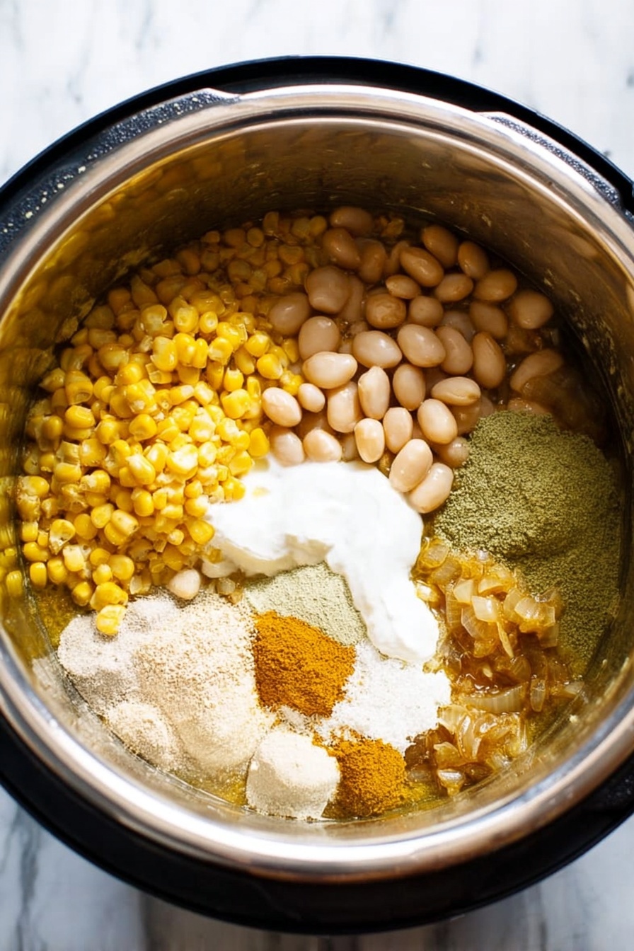 The dish is shown in a white bowl filled with three main layers. The bottom layer has shredded white chicken mixed with white beans and corn kernels which have a pale yellow color. The middle layer includes avocado chunks in light green and slices of fresh green jalapeños on top. The final layer is sprinkled with fresh green cilantro leaves and a wedge of bright green lime rests on the side. A silver spoon is placed inside the bowl. The scene is set on a white marbled texture surface with lime wedges and cilantro scattered around. Photo taken with an iphone --ar 2:3 --v 7